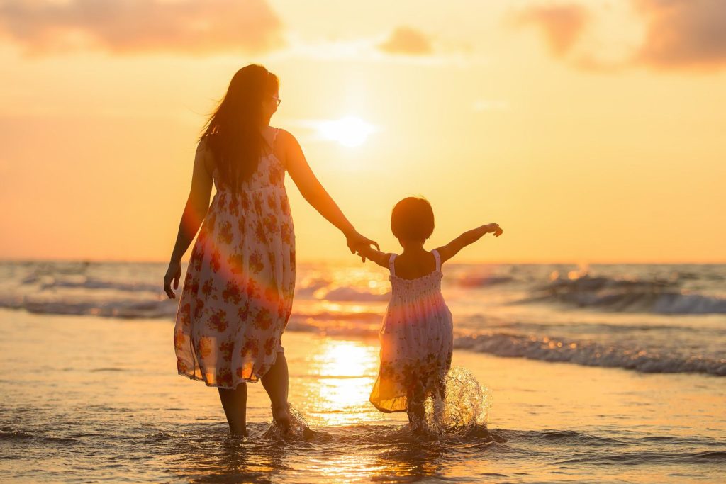 advantages of whole life insurance. Pic of a woman and her child at the beach during sunset