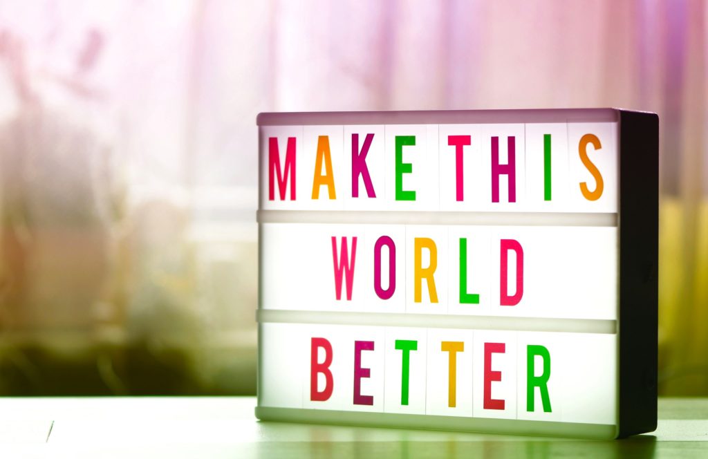 Picture of a sign that reads 'make the world better' referring to using premium financing to help charities